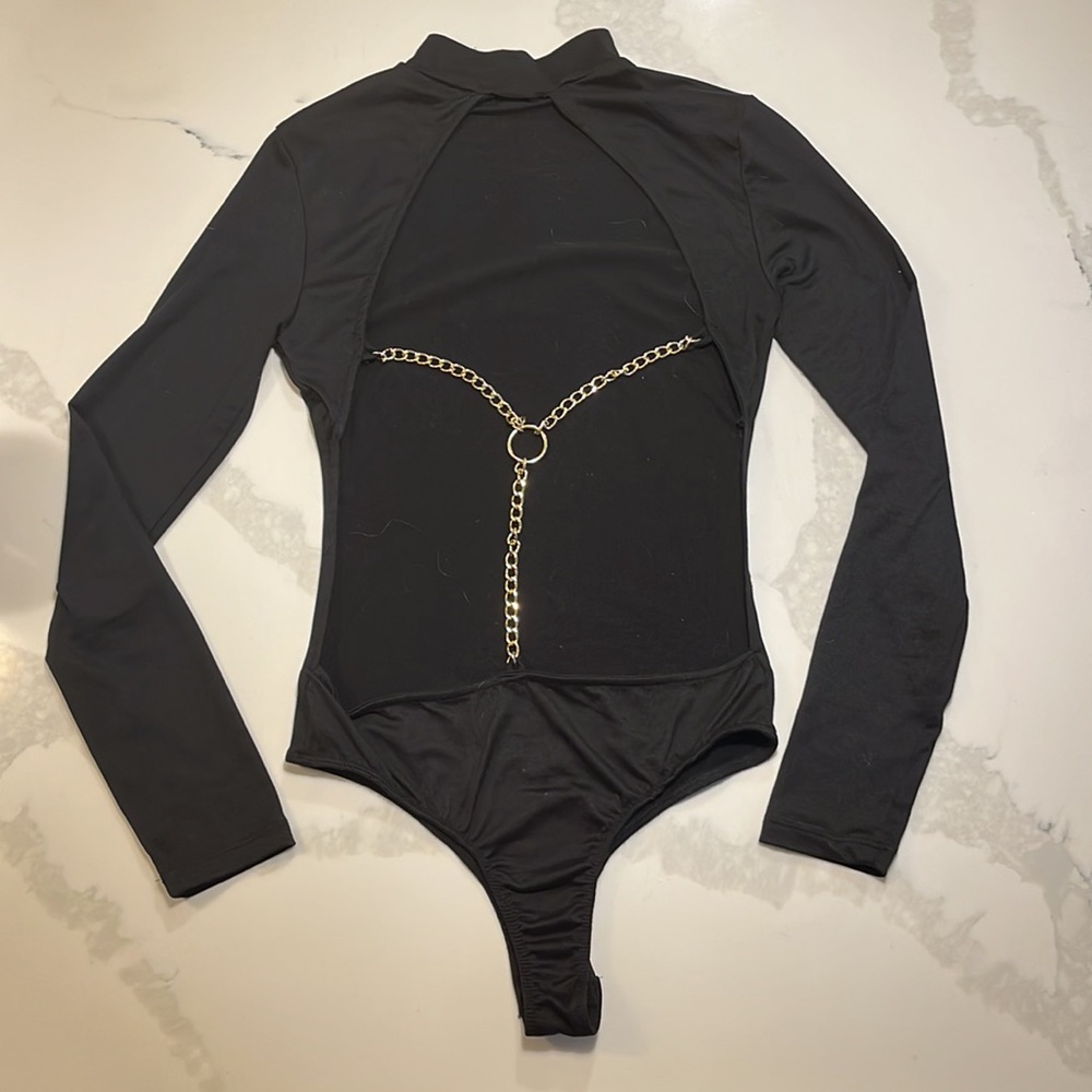 Black body suit with gold accent chain on back